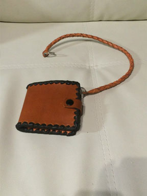 49. Рыжий кошелёк с тёмно-коричневой оплёткой и плетёным кожаным шнурком.